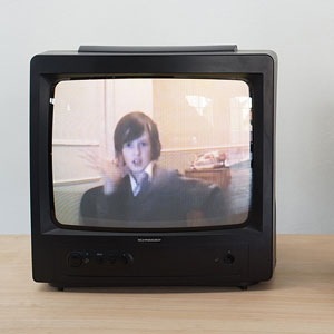A tv screen with a boy well dressed making statements in front of his webcam.